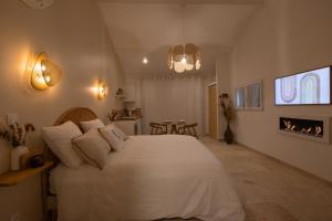 um quarto com uma cama branca e uma lareira em Nuits d'Audace em Alès