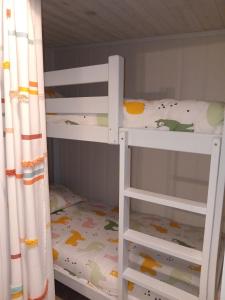 two white bunk beds in a room with a crib at CozyCocoon Appartement in Parcey