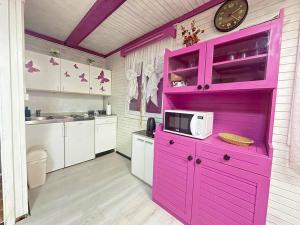 a kitchen with a pink cabinet and a microwave at Orhideja in Brežice