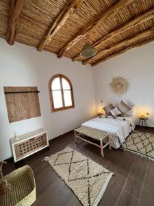 sypialnia z łóżkiem i kanapą w pokoju w obiekcie Le petit Chalet. w mieście As-Suwajra