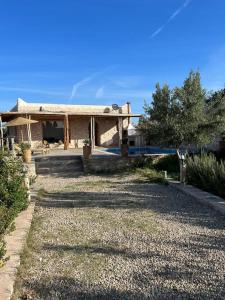 a house with a gravel driveway in front of it at Le petit Chalet. in Essaouira