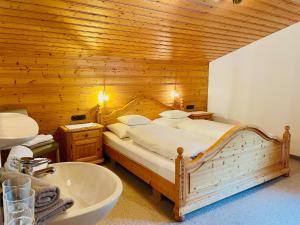 1 dormitorio con 1 cama grande y bañera en Haus Bitschnau, en Klösterle am Arlberg