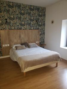 sypialnia z dużym łóżkiem z drewnianym zagłówkiem w obiekcie Restaurant Hôtel du Vercors w mieście Saint-Martin-en-Vercors
