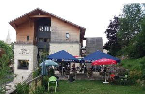 a restaurant with tables and umbrellas in front of a building at Restaurant Hôtel du Vercors in Saint-Martin-en-Vercors
