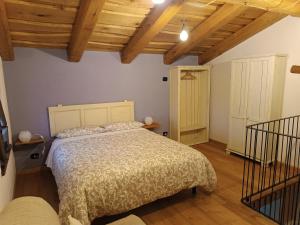 um quarto com uma cama num quarto com tectos em madeira em 'L ciabot 'd Ginota em Barge