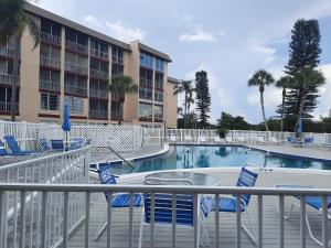 a pool with chairs and a table and a building at 4080 Lake Bayshore Drive in Bradenton