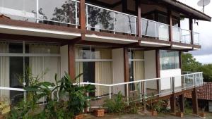 un immeuble d'appartements avec balcon et fenêtres dans l'établissement Hospedagem em Trindade Olhar Indígena Tomasia, à Parati