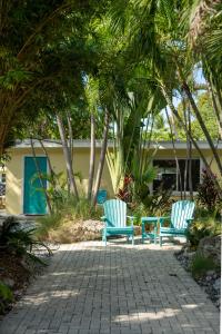 2 chaises bleues assises sur une terrasse avec des palmiers dans l'établissement Coconut Bay Resort - Key Largo, à Key Largo