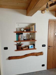 a shelf on a wall with books on it at 'L ciabot 'd Ginota in Barge