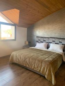 a bedroom with a large bed with a wooden ceiling at زاوية سيدي عبد السلام افران in Ifrane