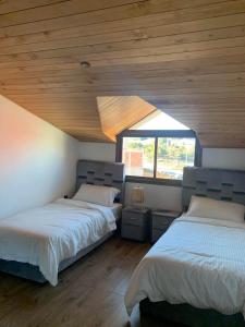 two beds in a room with wooden ceilings at زاوية سيدي عبد السلام افران in Ifrane