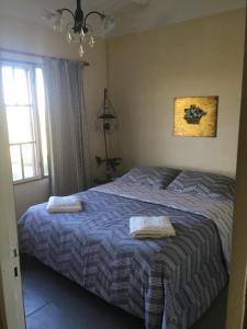 um quarto com uma cama com duas toalhas em La Madreselva em San Antonio de Areco