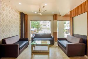 a living room with two couches and a coffee table at Super Collection O 75732 Hotel Aatithya in Bhubaneshwar