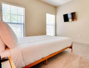um quarto com uma cama e uma televisão de ecrã plano em Pool, Gym - Cozy Apartment Oasis em Suwanee