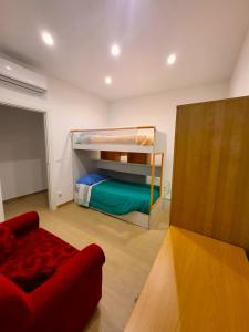 ein Schlafzimmer mit einem Etagenbett und einem roten Sofa in der Unterkunft Marta's Home in Molfetta