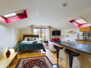 ein Schlafzimmer mit einem Bett und eine Küche mit einer Theke in der Unterkunft Gatelodge Studio, Ballyhackamore in Belfast