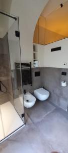 uma casa de banho com 2 WC e uma cabina de duche em vidro. em MATTEI LUXURY B&B em Altamura