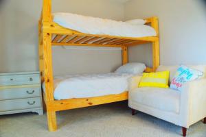 a bunk bed with a couch and a chair in a room at Cozy Family Retreat with Spa Bath Fenced Yard in New Bern