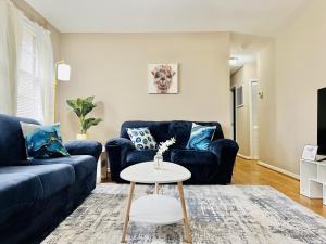 - un salon avec deux canapés bleus et une table dans l'établissement Cozy 4 bedroom Cottage by Duke Raleigh Hospital, à Raleigh