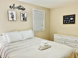 - une chambre avec un lit blanc, une commode et une fenêtre dans l'établissement Cozy 4 bedroom Cottage by Duke Raleigh Hospital, à Raleigh