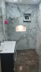 a bathroom with a sink and a marble wall at Private Room with attached Bathroom in The Hyde