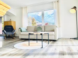 ein Wohnzimmer mit einem Sofa und einem Tisch in der Unterkunft Modern designed, luxury mountain view Apartment in Kandersteg