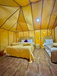 a bedroom with two beds in a tent at Your Family Camp in Merzouga