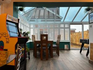 a dining room with a table and a video game at House few mins from beach with hot tub & sauna in Shoreham-by-Sea