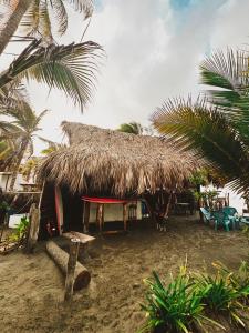 uma cabana com telhado de palha na praia em Sonar del Viento em San Bernardo del Viento