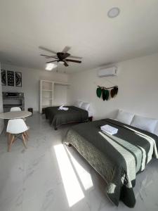 1 dormitorio con 2 camas y ventilador de techo en ALMAR FAMILY HOUSE en Isla Holbox