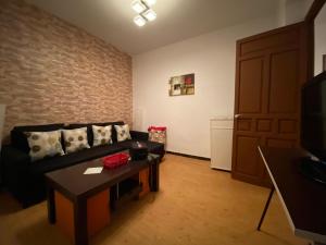 salon z kanapą, stołem i drzwiami w obiekcie Apartamento Callejon del Beso w Sewilli