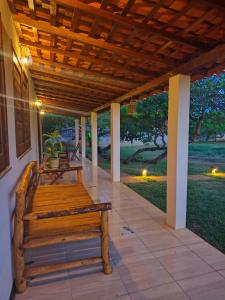 a porch with a wooden bench on a house at Bons Aires in Atins
