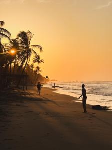 um grupo de pessoas caminhando na praia ao pôr do sol em Sonar del Viento em San Bernardo del Viento
