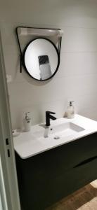 a bathroom with a sink and a mirror on the wall at chez Sherlock et Oscar in Bruyères