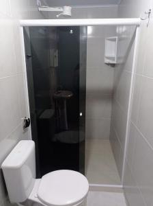 a bathroom with a toilet and a sink at Aloha Suites in Barra de São Miguel