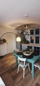 a dining room with a blue table and two chairs at chez Sherlock et Oscar in Bruyères