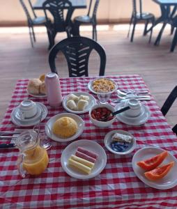 stół z talerzami żywności na czerwono-białej tkaninie w obiekcie Aloha Suites w mieście Barra de São Miguel