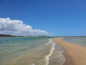 a beach with the ocean and clouds in the sky at Aloha Suites in Barra de São Miguel