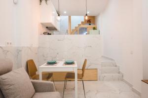 uma sala de jantar branca com uma mesa e cadeiras brancas em Casa Niña em Sevilha