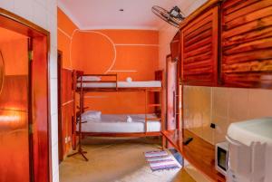 a room with two bunk beds and a tv at Hospedaria Vitória Mar in Ubatuba