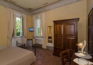 1 dormitorio con 1 cama, armario y mesa en B&B Villa La Perla, en Lucca