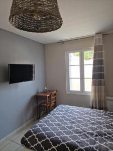 a bedroom with a bed and a television and a window at Les Chambres de Beaumont in Beaumont-Village