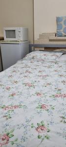 Cama en habitación con colcha floral en Cranford , Heathrow Airport, en Cranford