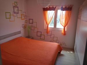 a bedroom with an orange bed and a window at Apartment Tara in Sumartin
