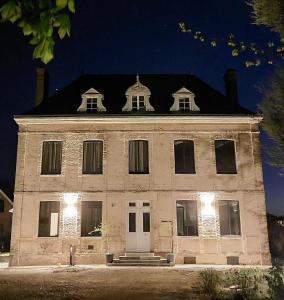 un gran edificio blanco con techo negro en LES JACQUEMARTS NORMANDS Maison d'hôtes - Guesthouse, en Belmesnil