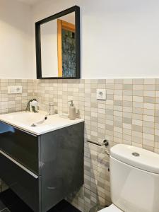 een badkamer met een wastafel, een toilet en een spiegel bij El Mirador del Naranco in Oviedo