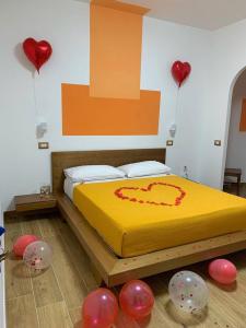 1 dormitorio con 1 cama con corazones rojos en la pared en Zia Bianca BeB, en Vietri