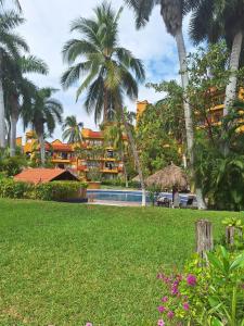 een resort met een zwembad en palmbomen bij Apartamento Colibrí in Ixtapa