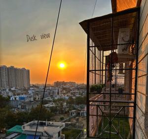 Blick auf eine Stadt bei Sonnenuntergang von einem Gebäude aus in der Unterkunft Elysium in Jaipur