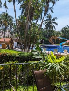 un complejo con piscina y palmeras en Apartamento Colibrí en Ixtapa